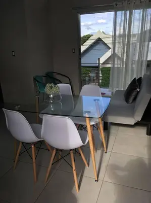 a glass table and chairs in a living room at Casa céntrica en San Ramón in San Ramón