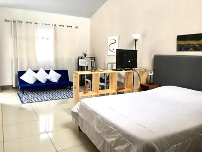 a bedroom with a bed and a tv and a couch at Apartamentos Sacor #1 Studio in Curridabat