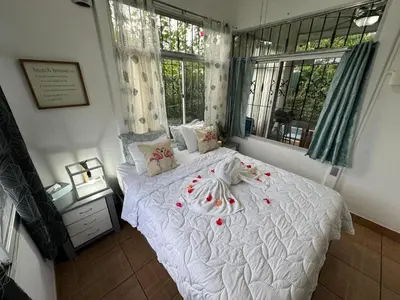 a bedroom with a white bed with flowers on it at Casa Willow Spacious and relaxing property in Ojochal