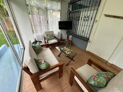 a view of a living room with chairs and a tv at Casa Willow Spacious and relaxing property in Ojochal