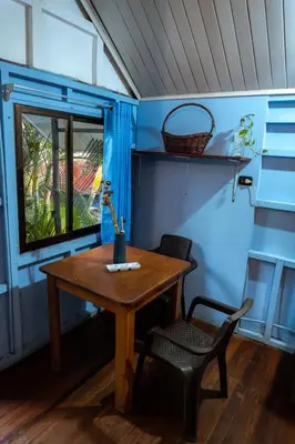a table and a chair in a room with a window at Surf Paradise in Santa Teresa Beach