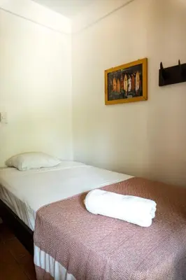a room with two beds and a picture on the wall at Surf Paradise in Santa Teresa Beach