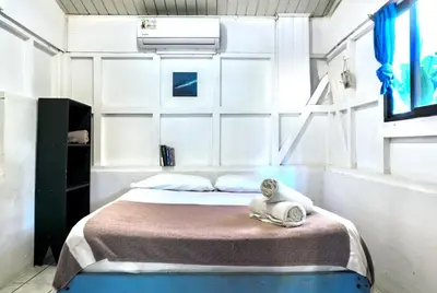 a bedroom with a bed with a swan sitting on it at Surf Paradise in Santa Teresa Beach