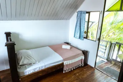 a small bedroom with a bed and a window at Surf Paradise in Santa Teresa Beach