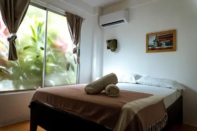 a bedroom with a bed with a towel on it at Surf Paradise in Santa Teresa Beach