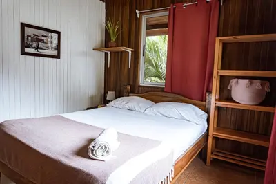 a small bedroom with a bed with a window at Surf Paradise in Santa Teresa Beach