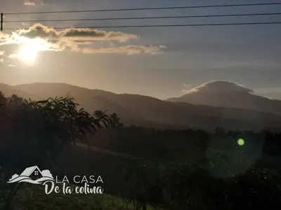 a view of the mountains with the sun setting in the background at Vista al Volcán Tenorio y Montaña in San Rafael