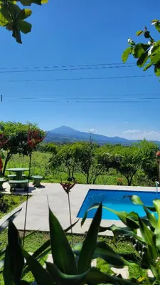 a view from the garden of a villa with a swimming pool at Vista al Volcán Tenorio y Montaña in San Rafael