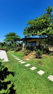 a garden with stepping stones in front of a house at Vista al Volcán Tenorio y Montaña in San Rafael