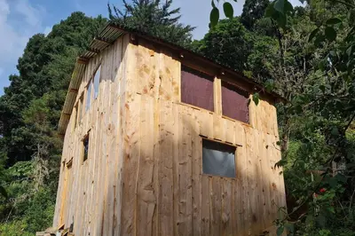 a wooden building in the middle of a forest at Cabaña El Descanso #1, Macho Mora Mountain Lodge in Alaska