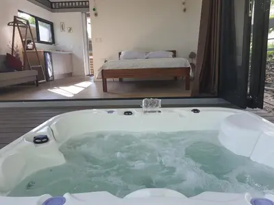a jacuzzi tub in a room with a bedroom at Nangu lodge in Sámara