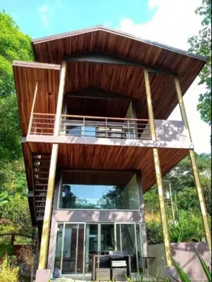 a tree house with a deck with a balcony at Tortuga Premium Riverfront Jungle Villa with Jacuzzi and Pool in Uvita