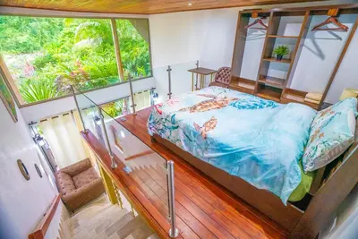 a bedroom with a bed and a large window at Tortuga Premium Riverfront Jungle Villa with Jacuzzi and Pool in Uvita