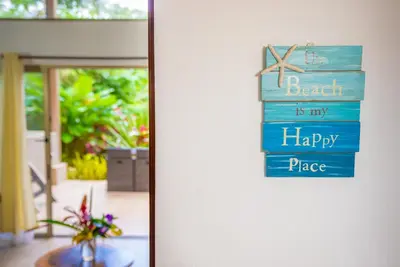 a sign that reads beach is my happy place on a door at Tortuga Premium Riverfront Jungle Villa with Jacuzzi and Pool in Uvita