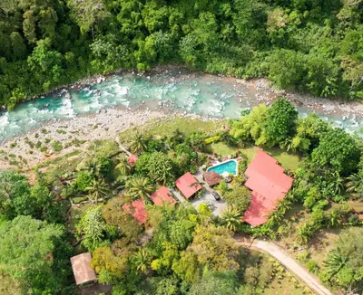 an aerial view of a house next to a river at Tortuga Premium Riverfront Jungle Villa with Jacuzzi and Pool in Uvita
