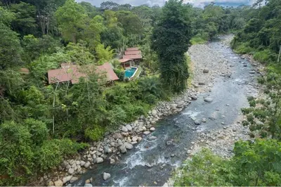 an aerial view of a river with a house at Sloth Premium Riverfront Jungle Villa with Jacuzzi and Pool in Uvita