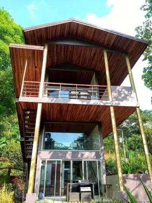 a tree house with a balcony in the woods at Sloth Premium Riverfront Jungle Villa with Jacuzzi and Pool in Uvita