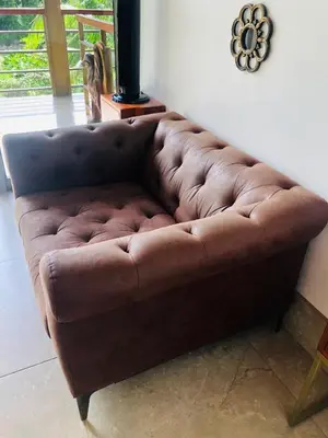 a brown leather couch sitting in a living room at Sloth Premium Riverfront Jungle Villa with Jacuzzi and Pool in Uvita