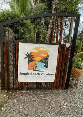 a gate with a beach vacation sign on it at Sloth Premium Riverfront Jungle Villa with Jacuzzi and Pool in Uvita