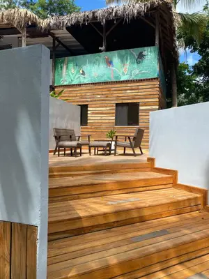 a wooden deck with two benches and a building at Quinta Esencia in Brasilito