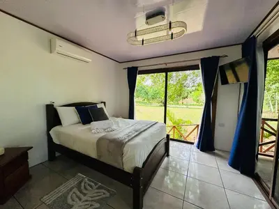 a bedroom with a bed and a large window at Cabañas Del Lago . Bungalows in San Ramón