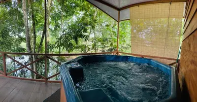 a hot tub on the deck of a house at Cabañas Del Lago . Bungalows in San Ramón