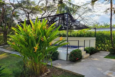 a garden with a pool and a plant at Pura Vida - Villa Elenita in Parrita