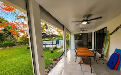 a dining room with a table and chairs on a patio at Pura Vida - Villa Elenita in Parrita