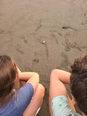 two children sitting on the sand at the beach at Pura Vida - Villa Elenita in Parrita