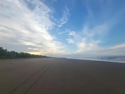 a view of a sandy beach with a cloudy sky at Pura Vida - Villa Elenita in Parrita