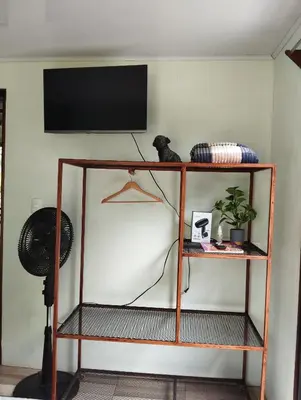 a shelf with a flat screen tv on a wall at Breezes Ecolodge in San Ramón