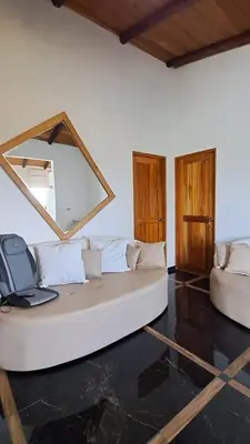 a living room with a white couch and a mirror at Casa Namaste del Pacifico - Luxury Villa in Santa Teresa Beach