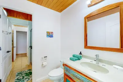 a bathroom with a sink and a toilet and a mirror at Casa Garrobo in Dominical