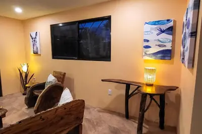 a living room with a bench and a table at Casa Garrobo in Dominical