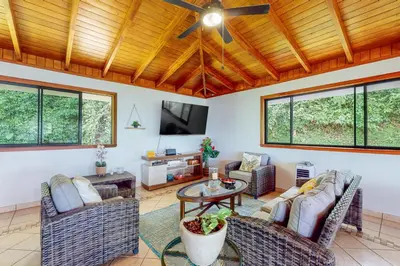 a living room with couches and a ceiling fan at Casa Garrobo in Dominical
