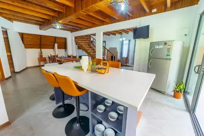 a kitchen with a table and chairs and a refrigerator at Casa Violeta Home rentals in Monteverde Costa Rica
