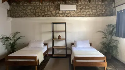 a room with two beds and a shelf on the wall at Dream Surf House Avellana in Playa Avellana