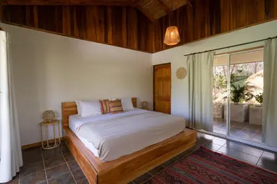 a bedroom with a bed and a large window at Dream Surf House Avellana in Playa Avellana