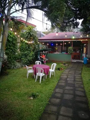 a table and chairs in a yard with a pink table cloth at Hotel Paradise Alajuela in Alajuela City