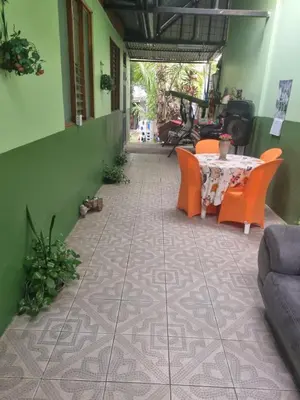 a patio with a table and chairs on a tiled floor at Hotel Paradise Alajuela in Alajuela City
