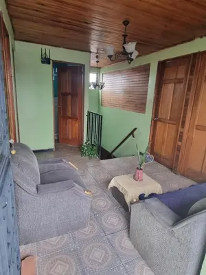 a living room with two couches and a table at Hotel Paradise Alajuela in Alajuela City