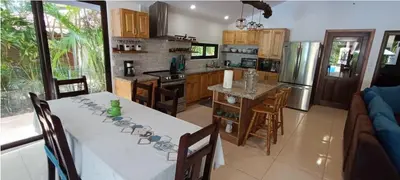a kitchen with a dining table and a kitchen with at Golf Beach House w/ Pool (5 min. walk to beach!) in Tambor
