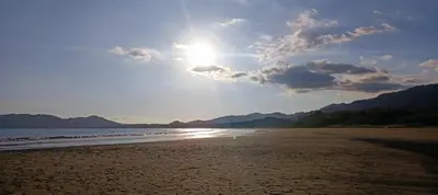 a view of a beach with the sun in the sky at Golf Beach House w/ Pool (5 min. walk to beach!) in Tambor