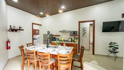 a dining room with a table and a kitchen at Villa Aurora with Jacuzzi in La Fortuna in Fortuna