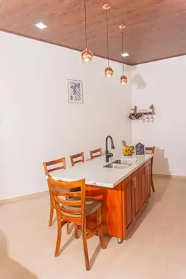 a kitchen with a sink and a table with chairs at Villa Aurora with Jacuzzi in La Fortuna in Fortuna
