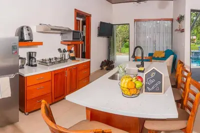 a kitchen with a table with a bowl of fruit on it at Villa Aurora with Jacuzzi in La Fortuna in Fortuna