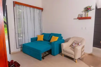 a living room with a blue couch and a chair at Villa Aurora with Jacuzzi in La Fortuna in Fortuna