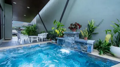 a swimming pool with a waterfall in a house at Villa Aurora with Jacuzzi in La Fortuna in Fortuna