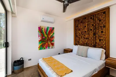 a bedroom with a bed and a painting on the wall at Casa Cenizaro- 4Br House In Hacienda Pinilla in Tamarindo