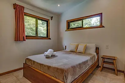 a bedroom with a large bed with two windows at Surfside Apartments - Mal Pais in Mal País